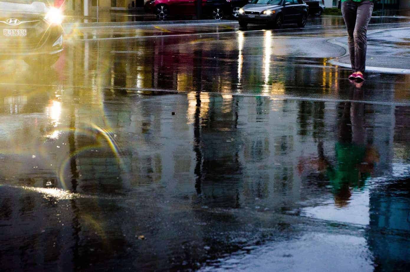 Eine von Wasser bedeckte Straße, auf der sich Autos spiegeln