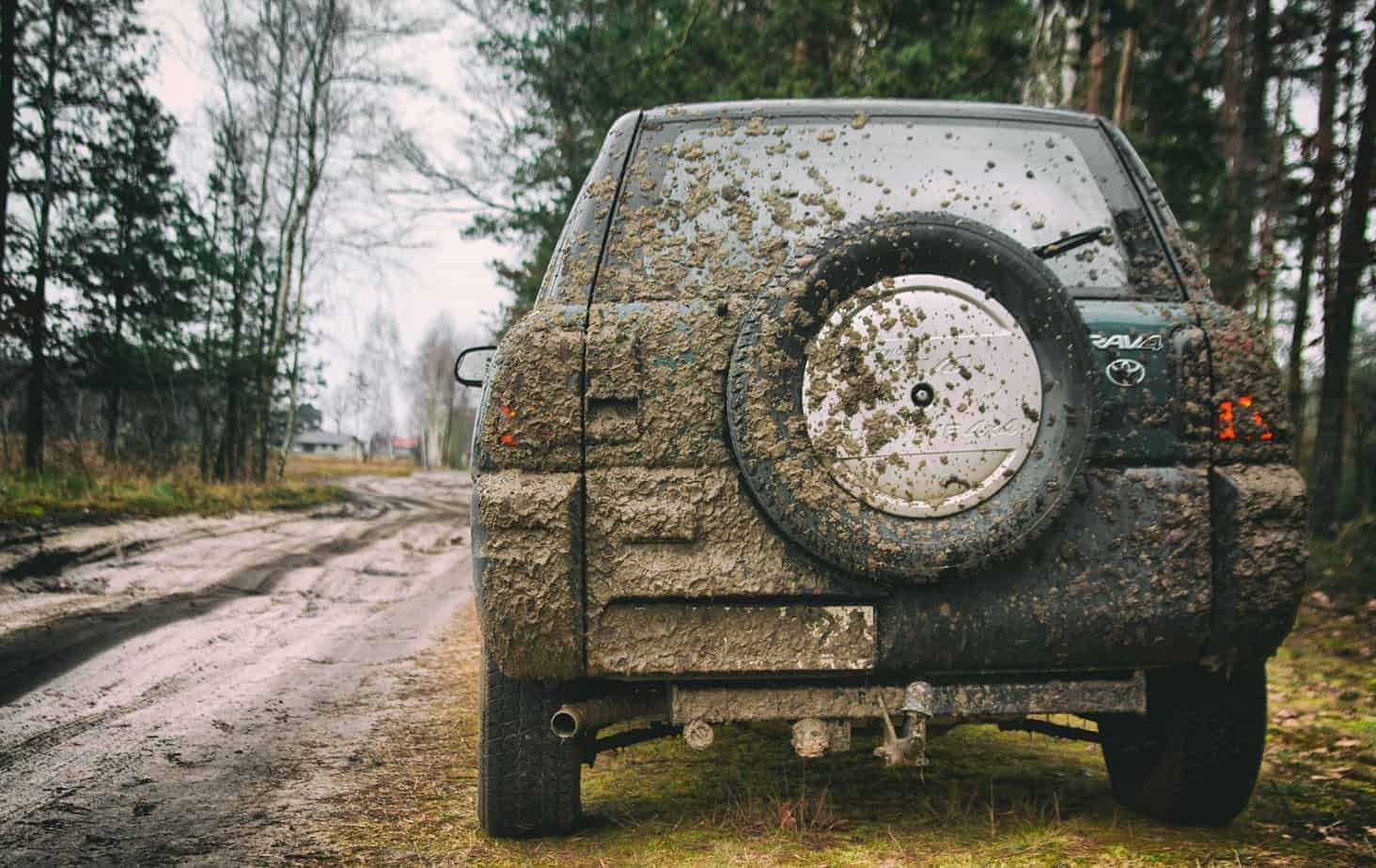 Verschmutzter Jeep am Straßenrand