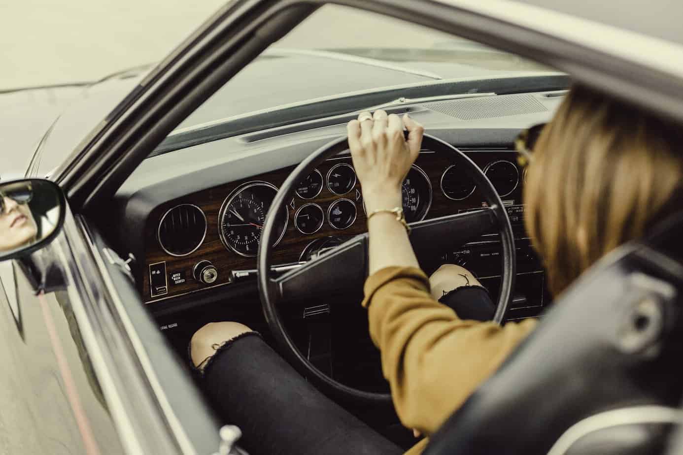 Frau hinter dem Steuer eines Oldtimers
